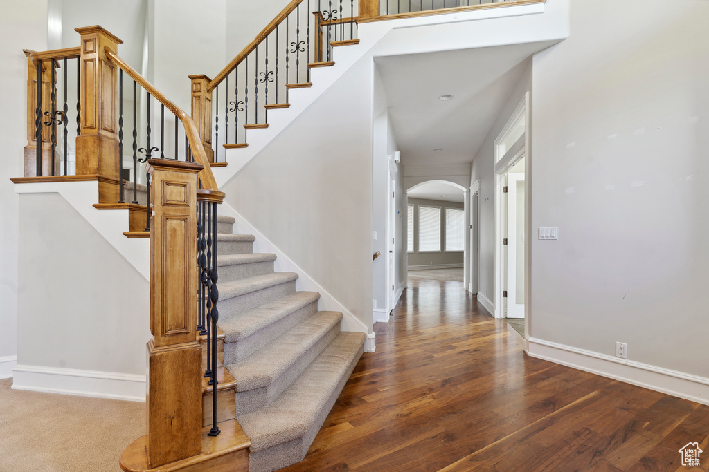 Interior space featuring arched walkways, baseboards, and wood finished floors