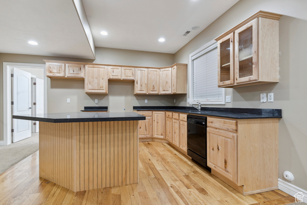 Kitchen with glass insert cabinets, light brown cabinetry, a center island, light wood-style floors, and black dishwasher