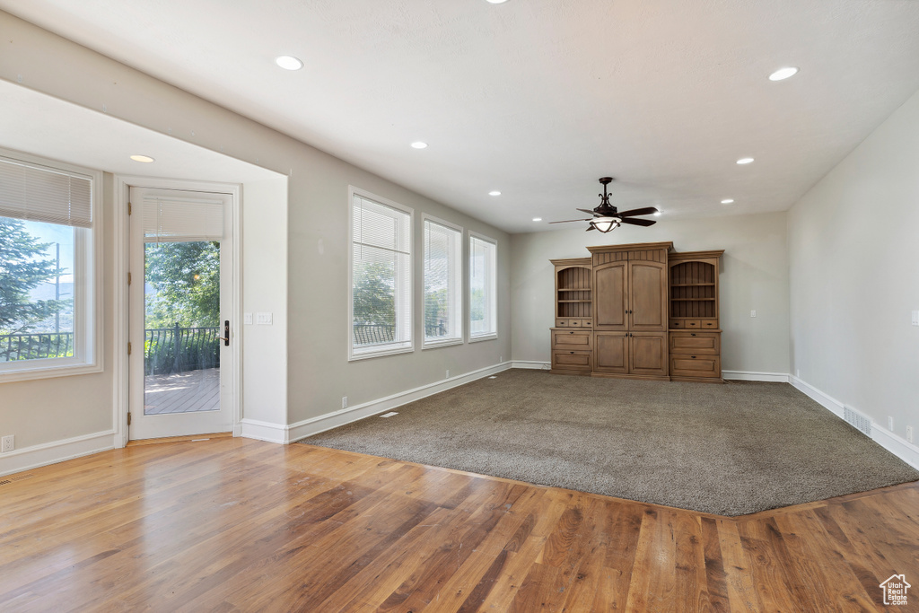 Unfurnished living room with recessed lighting and baseboards