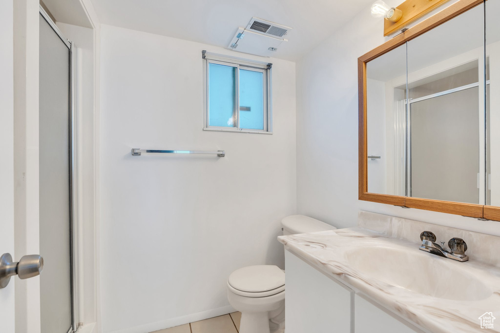 Full bathroom featuring tile patterned flooring, a shower with shower door, toilet, and visible vents