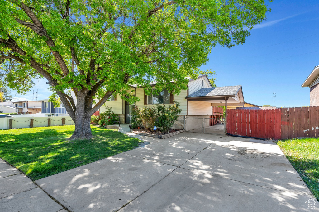 Obstructed view of property with fence, a gate, brick siding, and a front yard