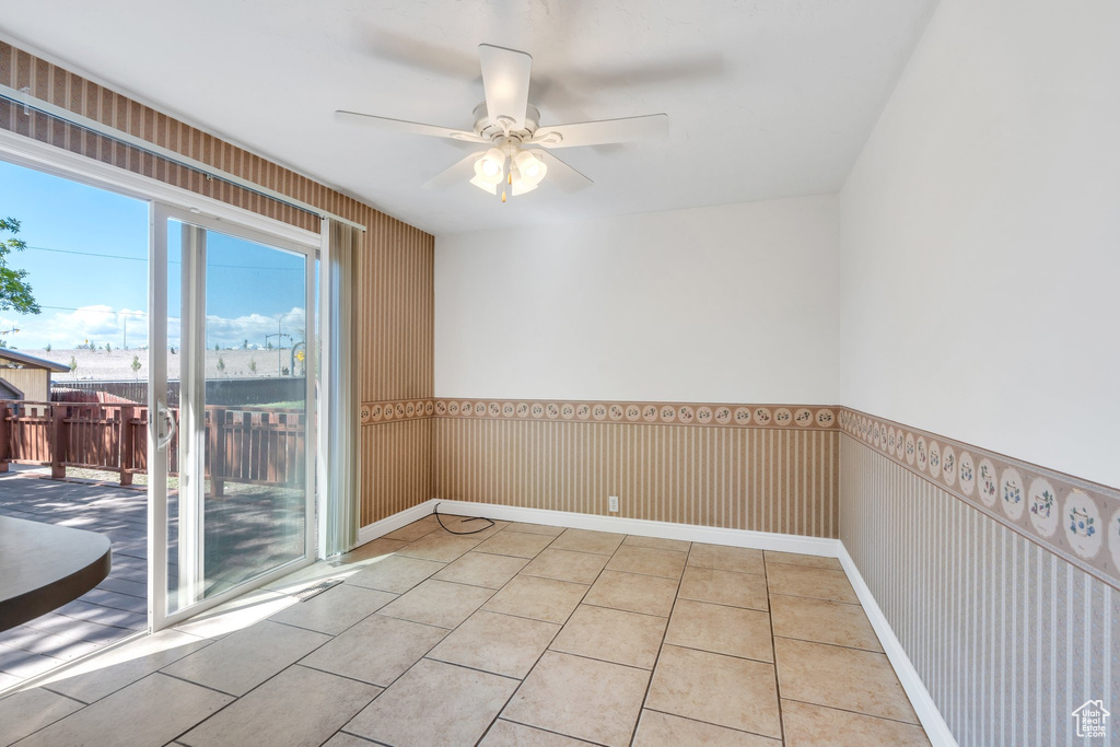 Empty room with light tile patterned floors and a ceiling fan