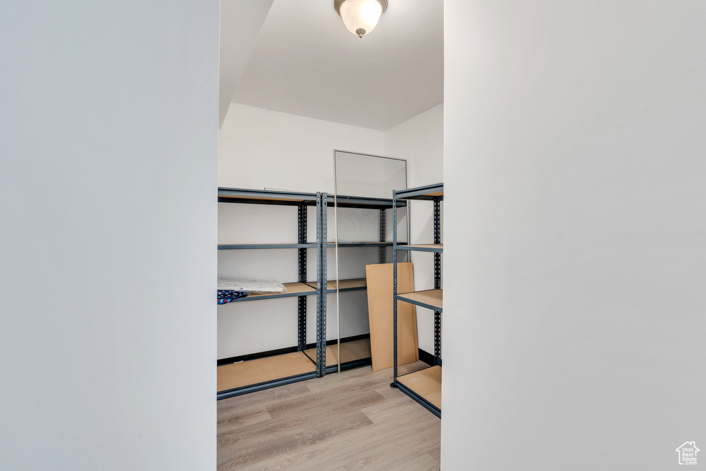 Walk in closet with wood finished floors