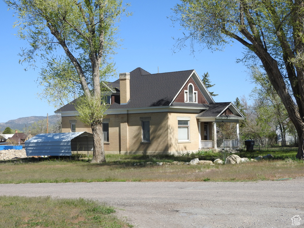 View of front of property with a porch and a chimney