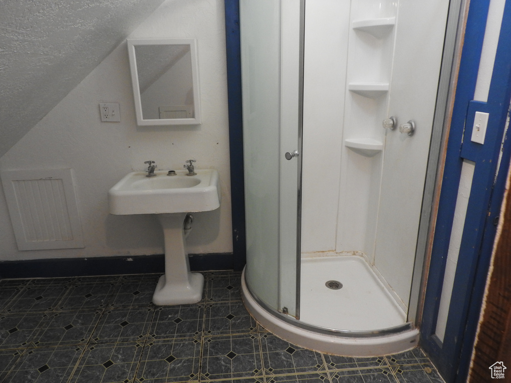 Bathroom with visible vents, a textured ceiling, vaulted ceiling, and a shower stall