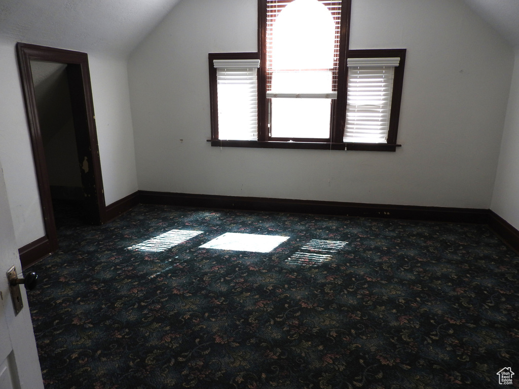 Bonus room featuring carpet floors, baseboards, and vaulted ceiling