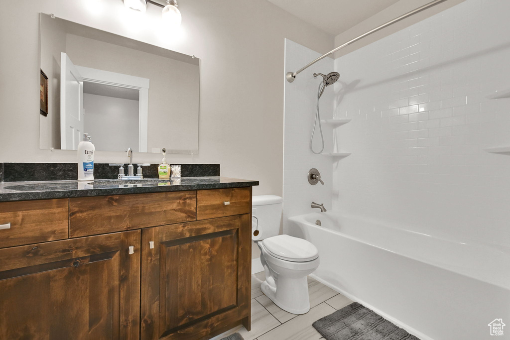 Bathroom with shower / bath combination, vanity, and toilet