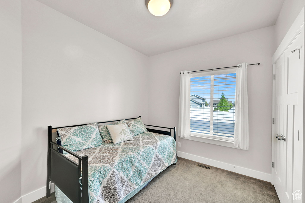 Carpeted bedroom with baseboards and visible vents