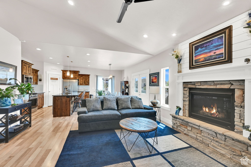 Living room featuring vaulted ceiling, recessed lighting, and light wood-style flooring