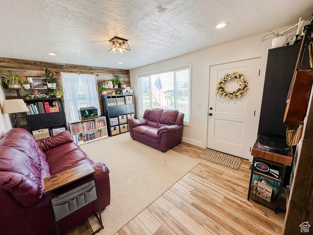 Living area featuring recessed lighting, light wood finished floors, and a textured ceiling