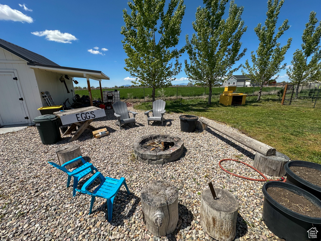 View of yard with an outdoor fire pit and fence