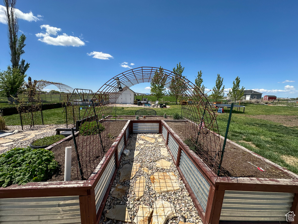 View of property\'s community featuring a lawn and a vegetable garden
