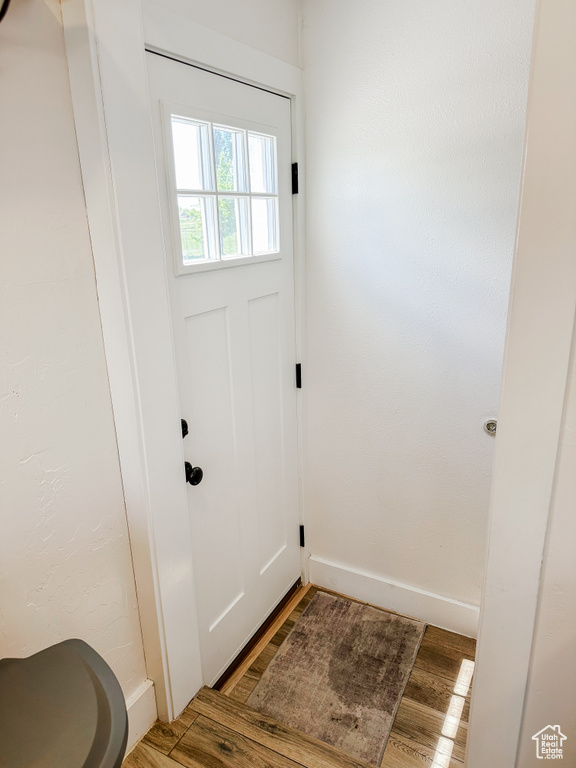 Doorway to outside with baseboards and wood finished floors