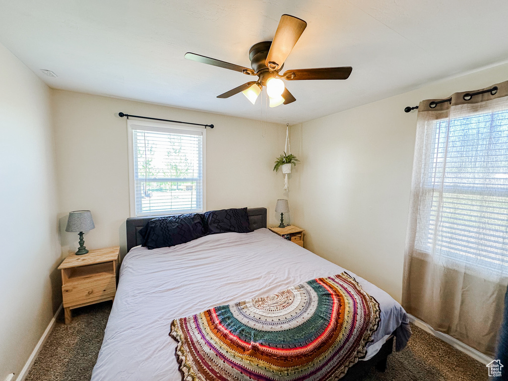 Carpeted bedroom featuring baseboards and a ceiling fan