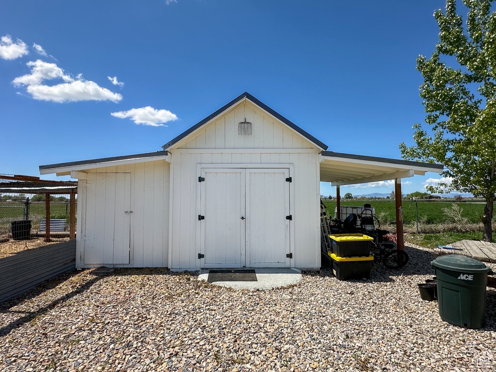 View of shed featuring fence and cooling unit