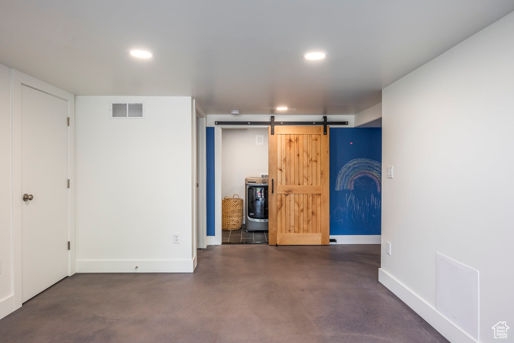 Basement featuring recessed lighting, baseboards, visible vents, and a barn door