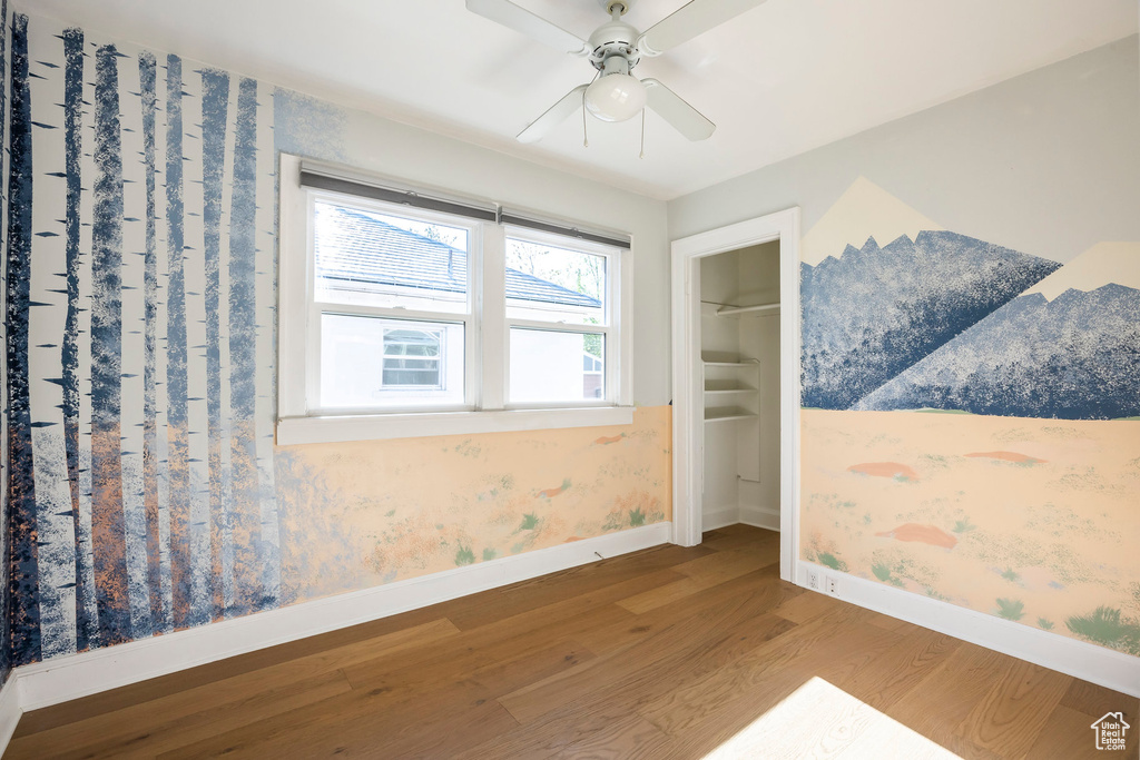 Interior space with baseboards, ceiling fan, and wood finished floors
