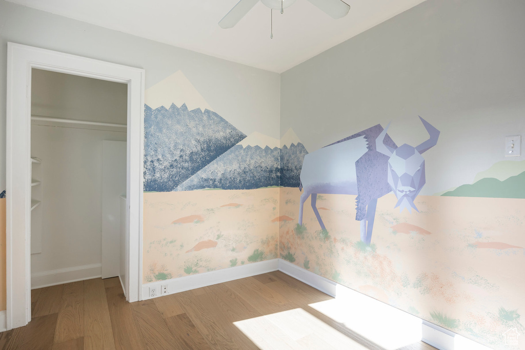 Unfurnished bedroom with baseboards, wood finished floors, and a closet
