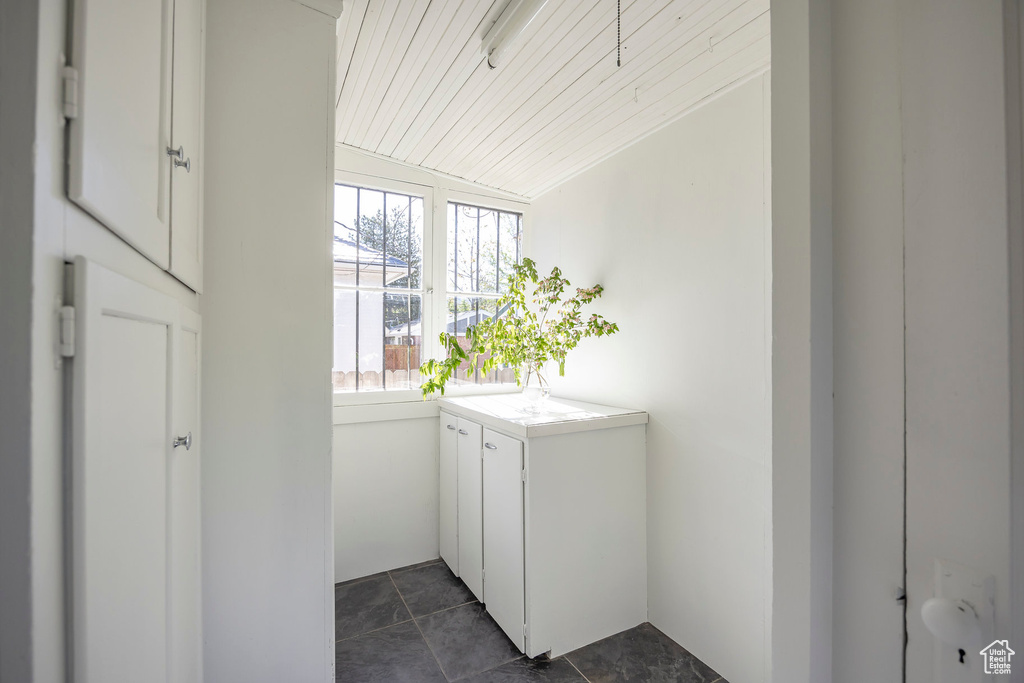 Interior space with dark tile patterned flooring and wood ceiling