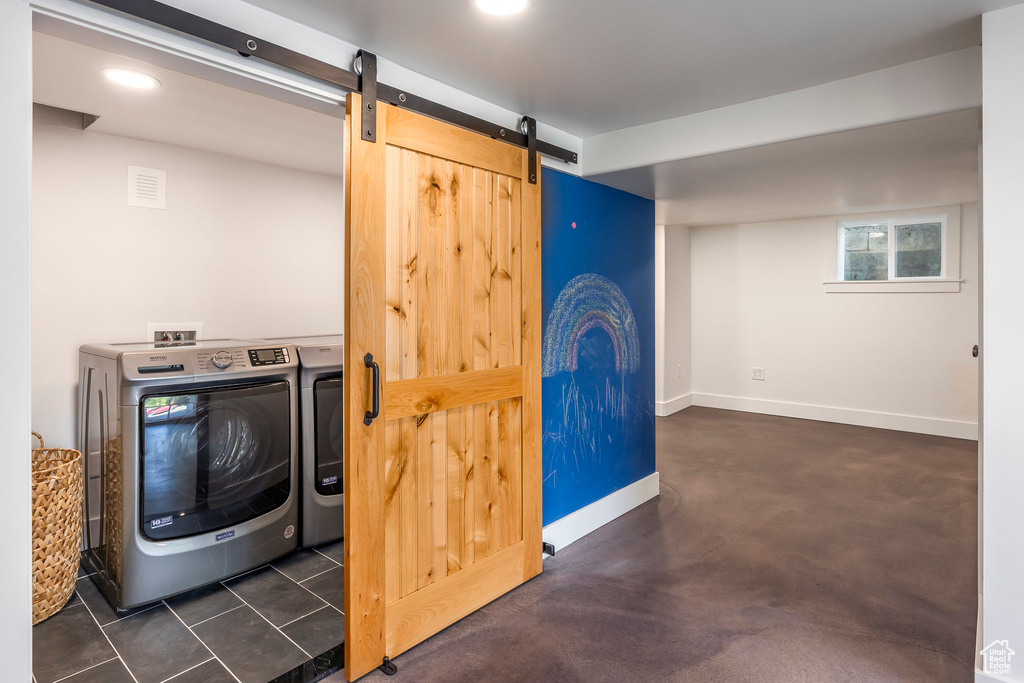Clothes washing area featuring laundry area, independent washer and dryer, a barn door, baseboards, and recessed lighting