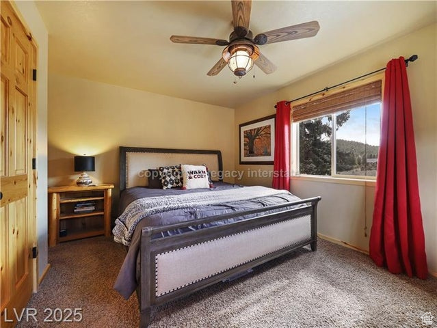 Carpeted bedroom with baseboards and ceiling fan