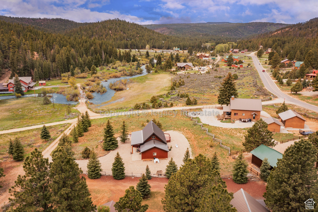 View from above of property featuring a heavily wooded area and a mountainous background