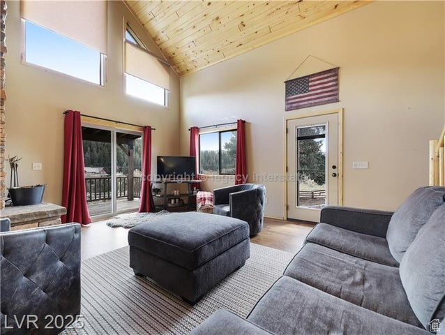 Living room with wood ceiling, wood finished floors, and high vaulted ceiling
