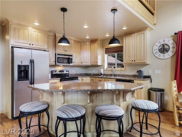 Kitchen featuring stainless steel appliances, recessed lighting, light wood-type flooring, and a center island