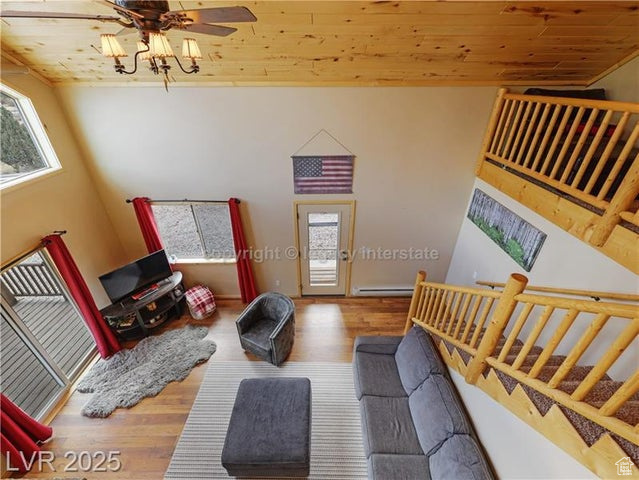 Living area featuring stairway, wooden ceiling, ceiling fan, and wood finished floors