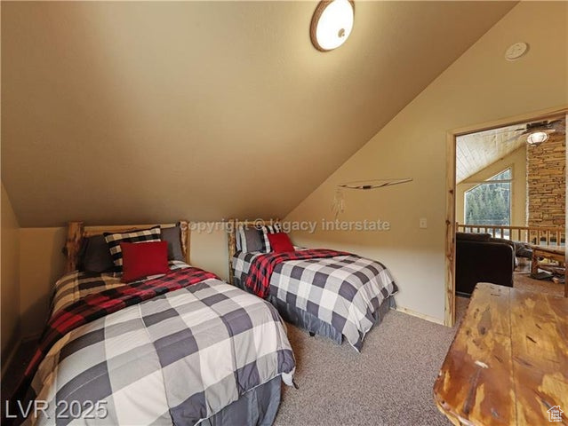 Bedroom with carpet floors and vaulted ceiling
