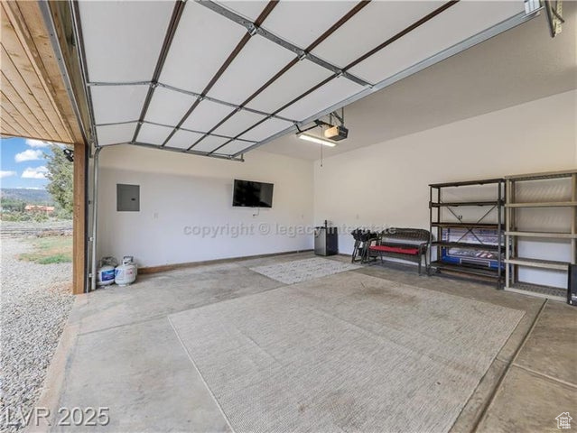 Garage featuring a garage door opener and electric panel