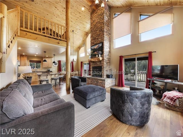 Living room with wooden ceiling, high vaulted ceiling, and light wood-type flooring
