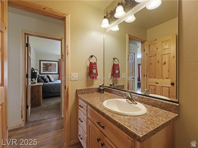 Bathroom with a chandelier, wood finished floors, and vanity