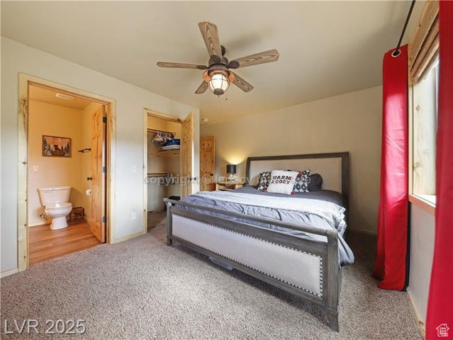 Bedroom featuring baseboards, a closet, a spacious closet, ensuite bathroom, and carpet flooring