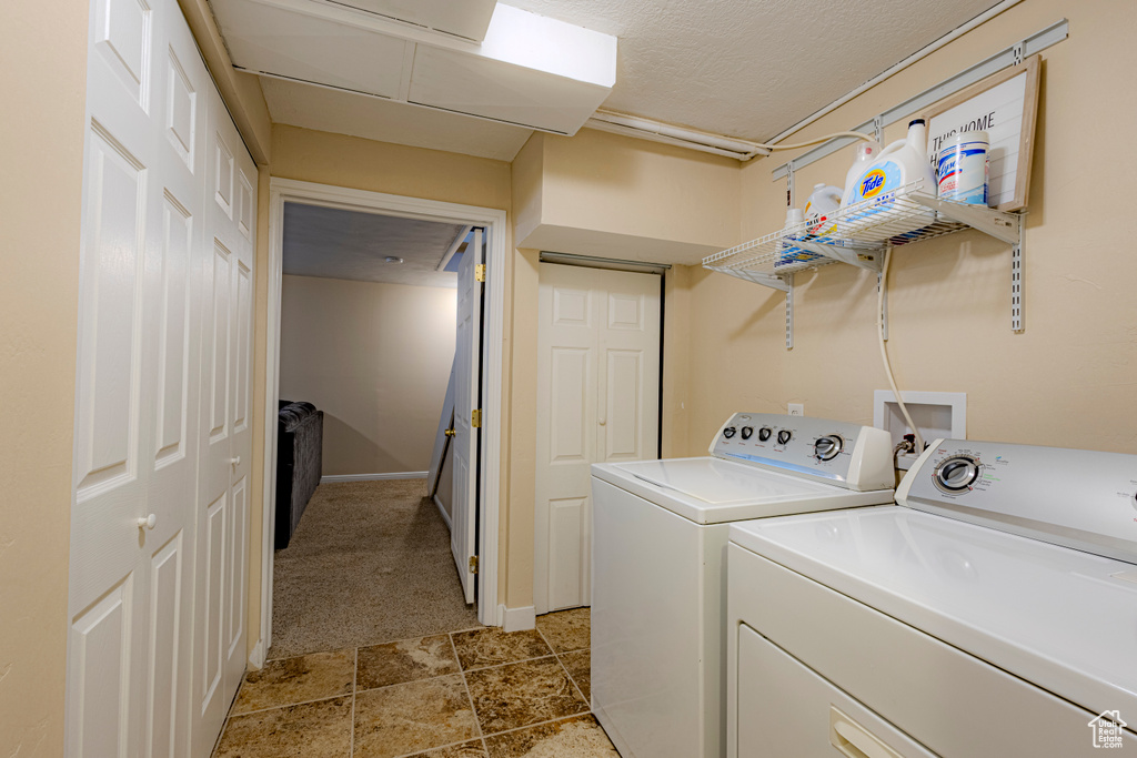 Washroom featuring separate washer and dryer, laundry area, and light carpet