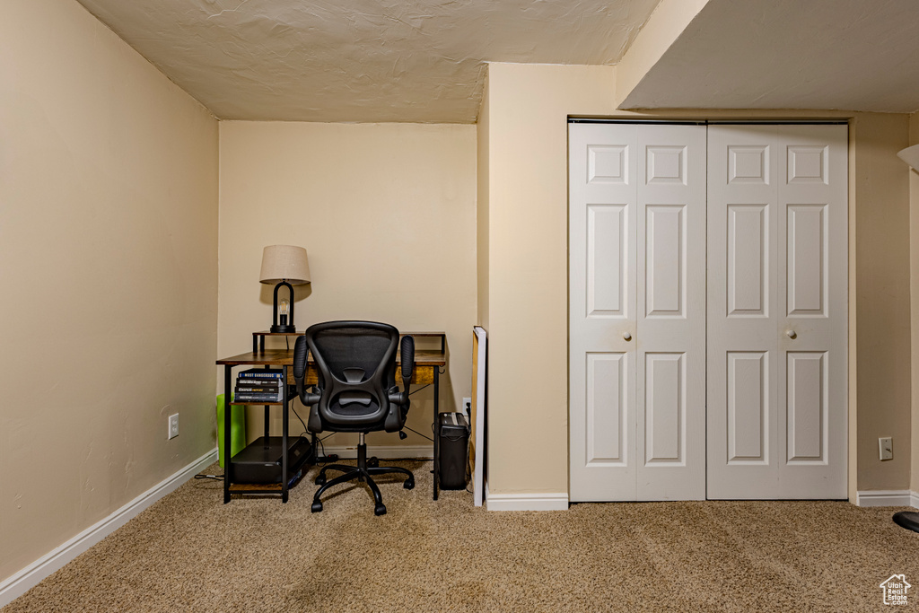 Office space with carpet floors, a textured ceiling, and baseboards