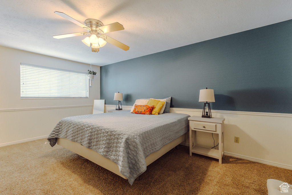 Carpeted bedroom featuring baseboards and ceiling fan