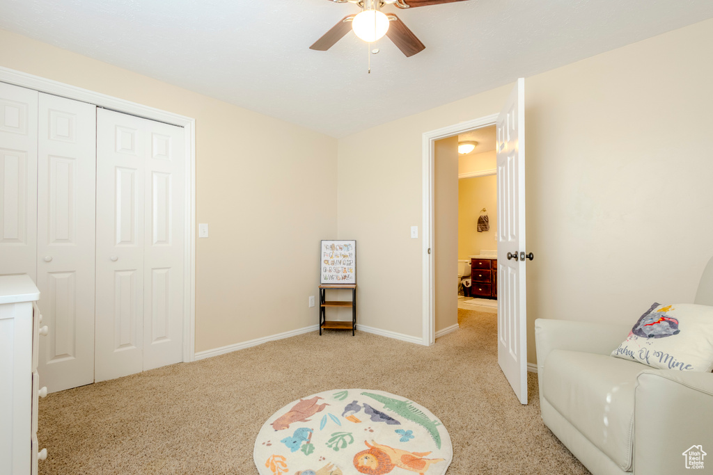 Interior space featuring baseboards, a ceiling fan, and light colored carpet
