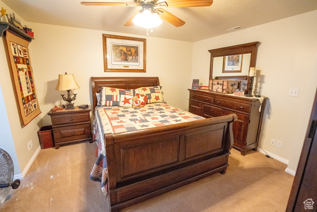 Bedroom with baseboards, visible vents, and light carpet