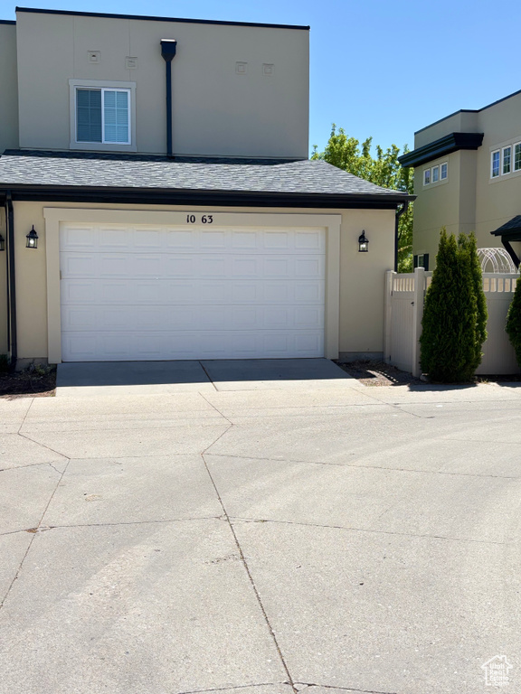 Garage featuring fence and driveway