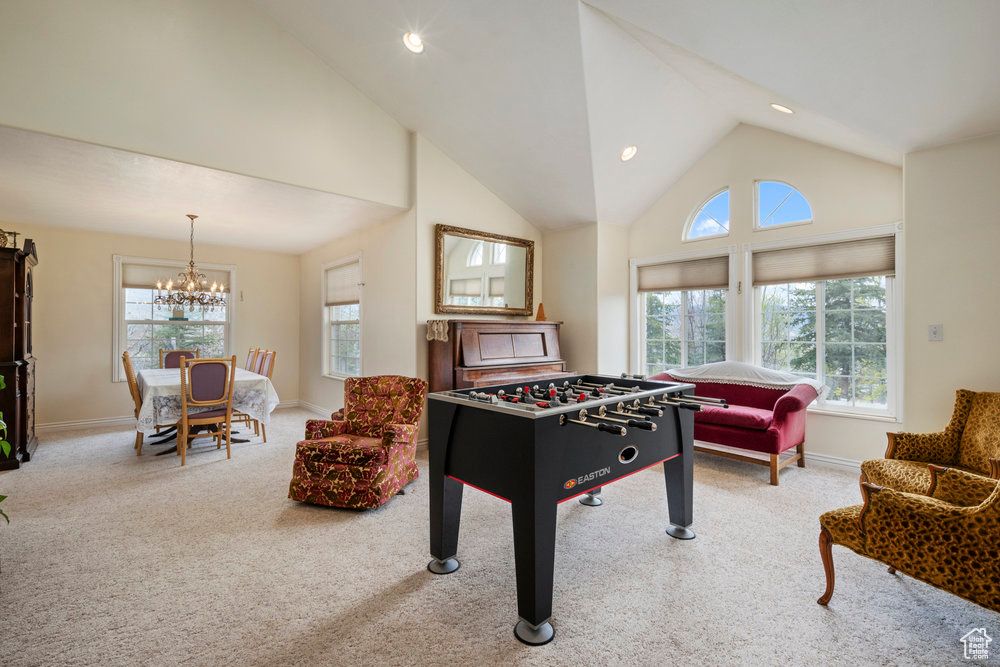 Recreation room with baseboards, a notable chandelier, a healthy amount of sunlight, and carpet