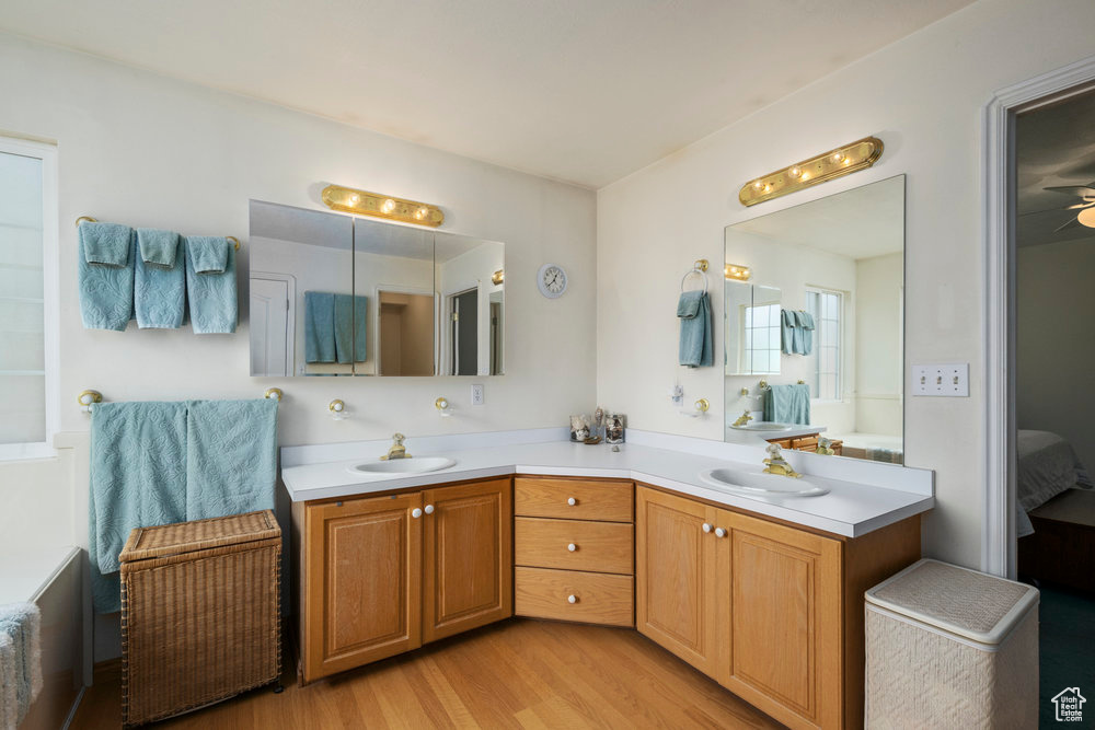 Full bath with wood finished floors, a sink, ensuite bath, and double vanity