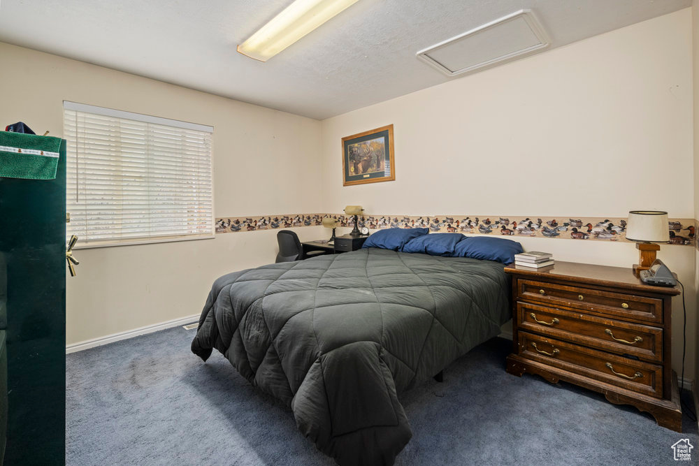 Bedroom featuring baseboards, attic access, and carpet flooring