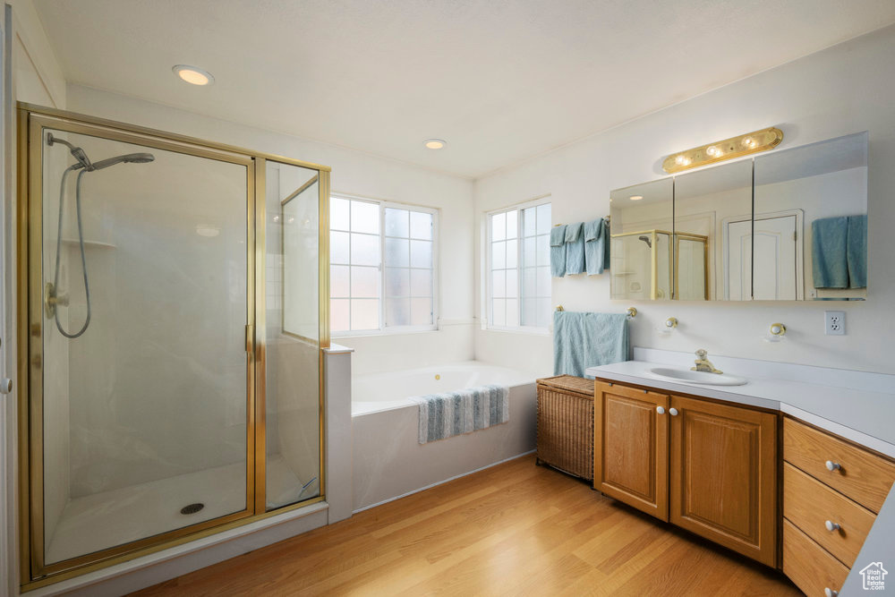 Bathroom with vanity, wood finished floors, recessed lighting, a bath, and a shower stall