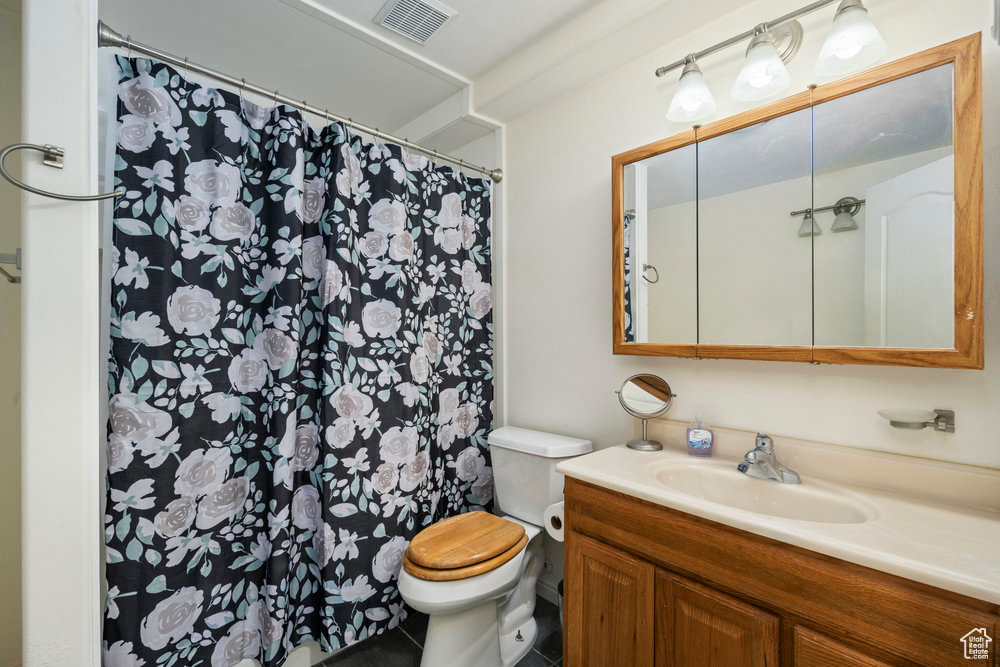 Full bath with vanity, toilet, tile patterned floors, a shower with curtain, and visible vents