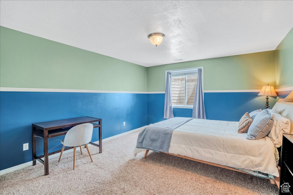 Carpeted bedroom with baseboards and a textured ceiling