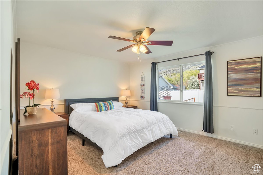 Bedroom featuring baseboards, a ceiling fan, and carpet