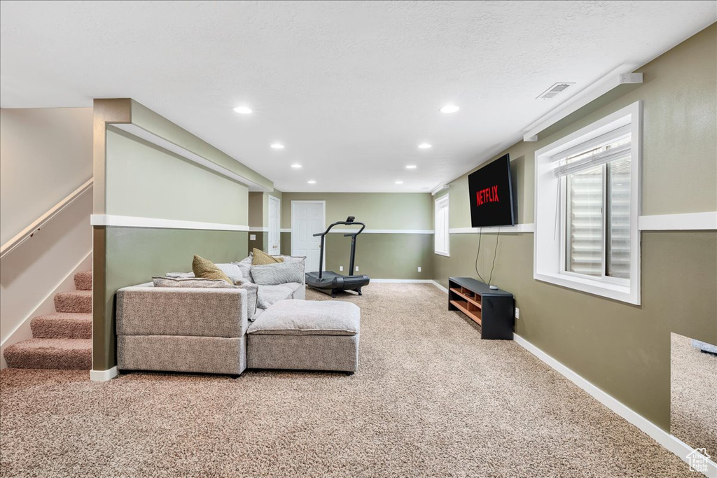 Carpeted living room featuring visible vents, recessed lighting, baseboards, and stairs