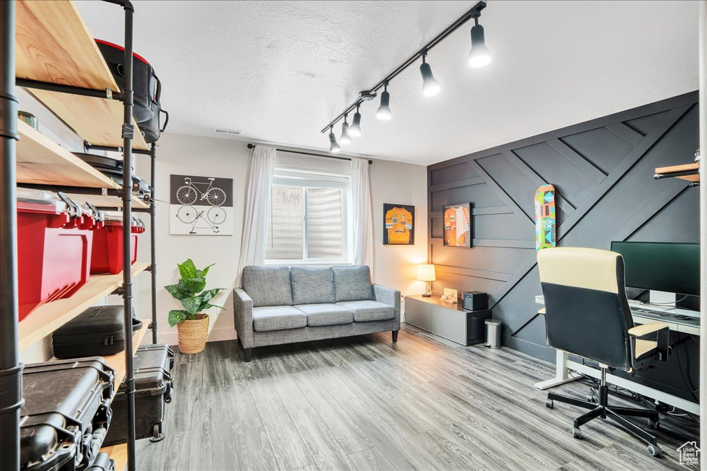 Office space featuring baseboards, a textured ceiling, and wood finished floors