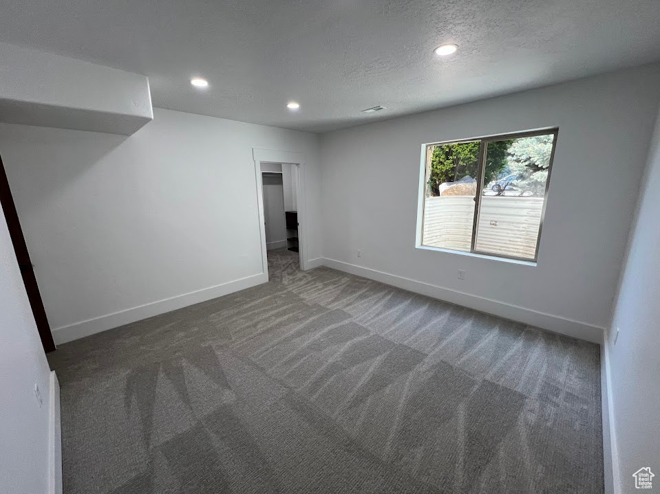 Unfurnished room featuring baseboards, recessed lighting, carpet, and a textured ceiling